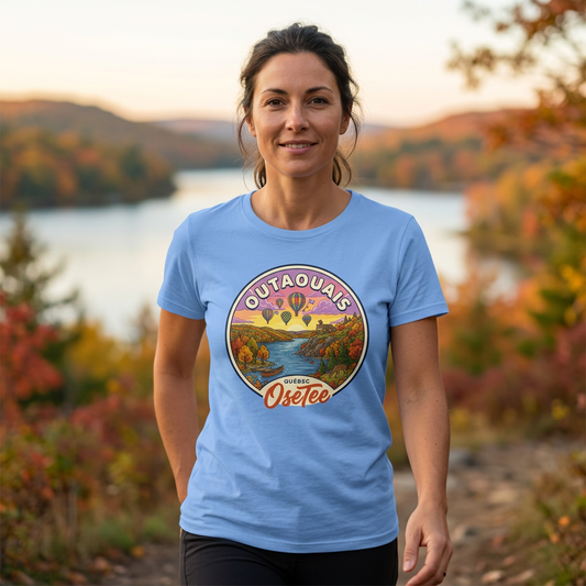 T-shirt bleu clair Outaouais OseTee porté en randonnée, cadrage rapproché sur le motif, avec paysage automnal en arrière-plan.